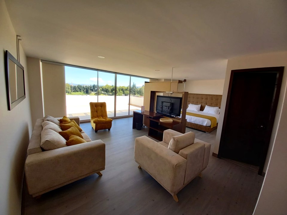 Suite del Hotel Harmony Ipiales con sala independiente, ventanal y balcón